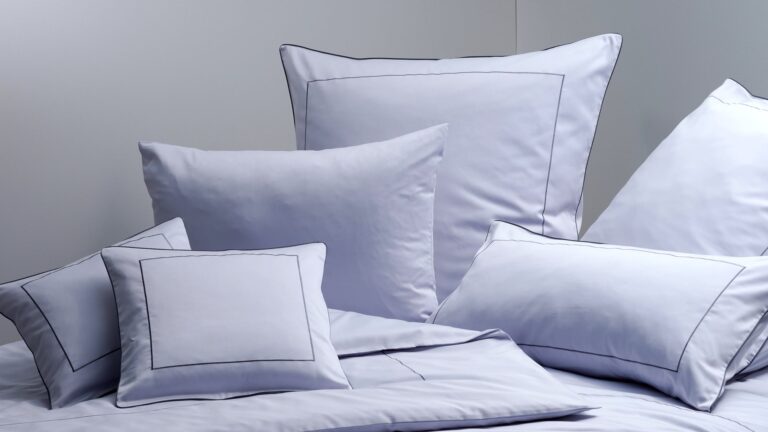 Mehrere Kissen mit hochwertigem Kopfkissenbezug von Graser liegen auf einem Bett. Zu kaufen bei Rüger1881 in Altdorf bei Nürnberg.