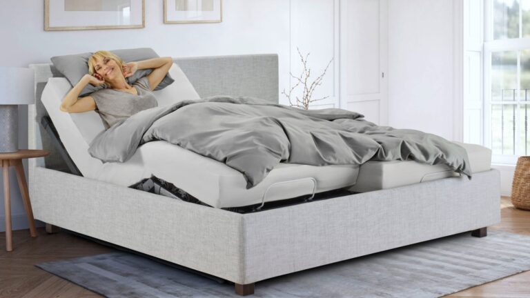 Eine Frau wacht erholt auf einem Bett mit einem Lattenrost von Lattoflex auf. Symbolisch für hochwertige Lattenroste made in Germany bei Rüger1881 in Altdorf bei Nürnberg.