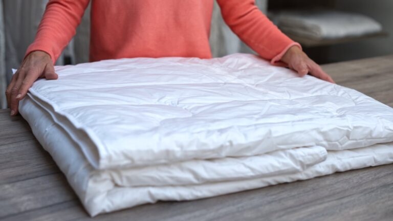 Ein Mann faltet eine Sommerdecke zusammen.